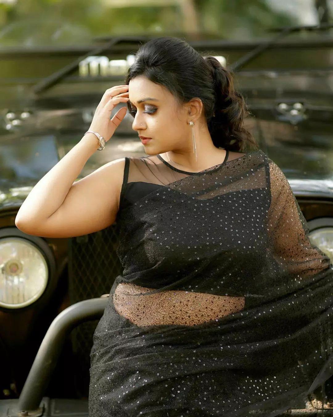 Glamorous and cute stills | Varada in black transparent saree hot photos