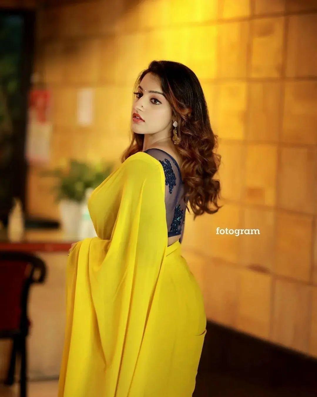 Glamorous and cute stills | Malavika Menon in yellow transparent saree hot and sexy photoshoot